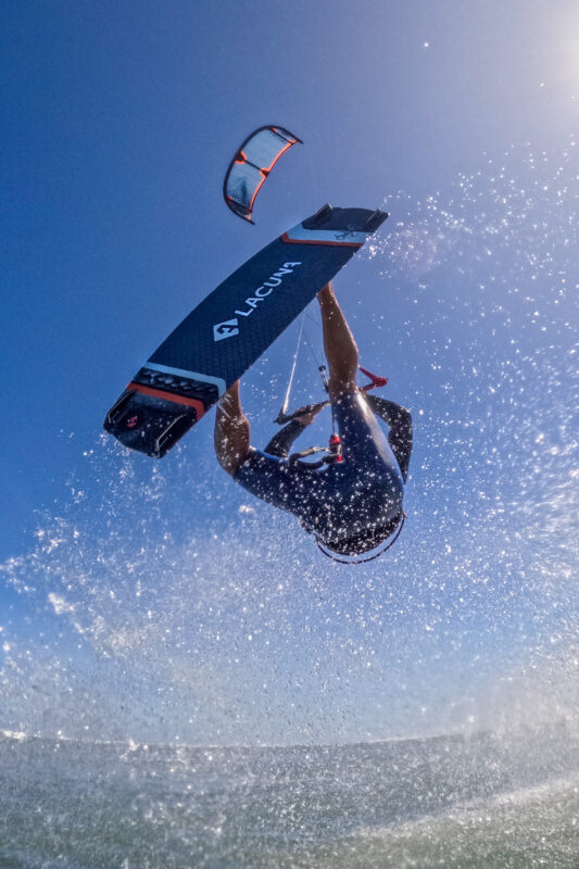 Kiteboarder riding shot from the water with Lacuna on the bottom of his board